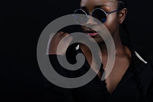 Confident african woman with dark skin wearing round sunglasses