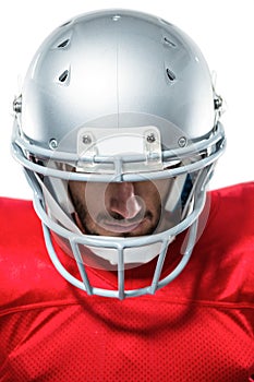 Confident American football player in red jersey looking down