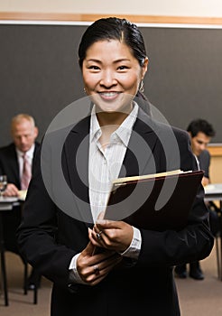 Confident Asian businessman holding files