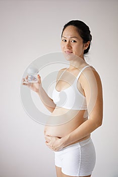 Confident Asian Chinese pregant mother holding milk bottle