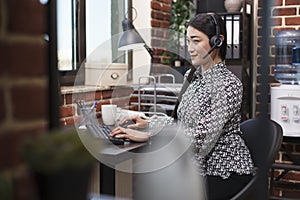 Confident asian customer support operator on voicecall with client