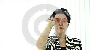 Confident Asian elderly woman stylish fashion dress colourful sunglasses and zebra pattern dress