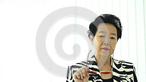 Confident Asian elderly woman with stylish fashion dress colourful sunglasses and zebra pattern dress