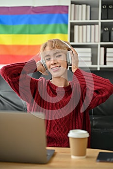 A confident Asian gay man enjoying the music on his headphones in his living room