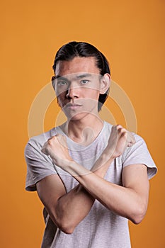 Confident asian man showing stop gesture portrait