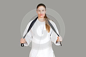 Confident attractive athletic woman in white kimono standing and