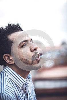 Confident attractive mulatto man smoking a cigarrette