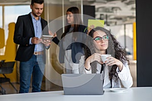 Confident attractive young business woman with tablet in hands in modern office start up office