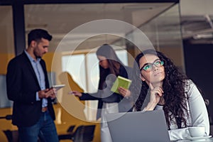 Confident attractive young business woman with tablet in hands in modern office start up office