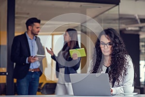 Confident attractive young business woman with tablet in hands in modern office start up office