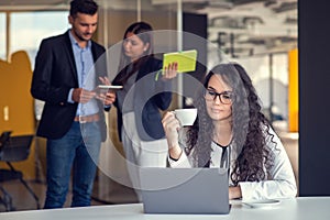 Confident attractive young business woman with tablet in hands in modern office start up office