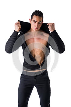 Confident, attractive young man with open sweater on muscular torso