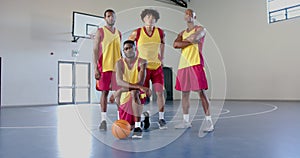 Confident basketball team posing in a gym