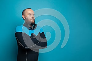 Confident bearded man in diver suit on blue banner background with copy space