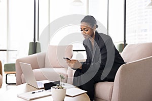 Confident beautiful African American businesswoman using cellphone for job communication