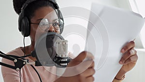 a confident and beautiful African-American woman with a microphone and headphones reads text,