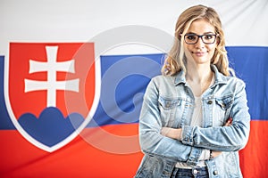Sebevědomá krásná Slovenka v brýlích stojí před vlajkou své země