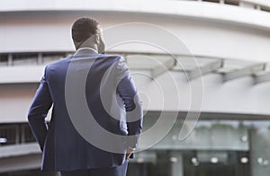 Confident black businessman against modern office center background