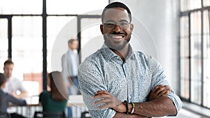 Confident black leader standing at modern company office feeling proud