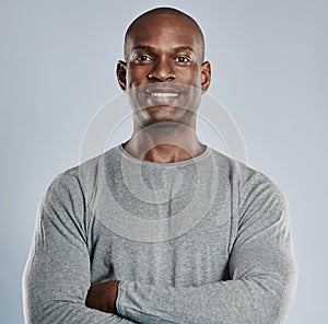 Confident black man with pleasant smile in gray