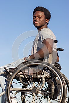 Confident Black man in wheelchair enjoying time outside