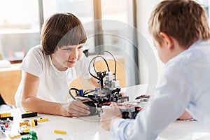 Confident boys happily using robotics for play photo