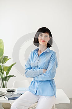 Confident business caucasian woman ceo wears formal clothes. Successful middle aged female with arms crossed standing by