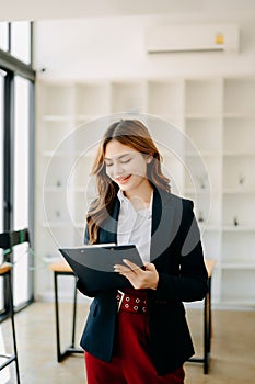 Confident business expert attractive smiling young woman holding digital tablet on desk in creative office