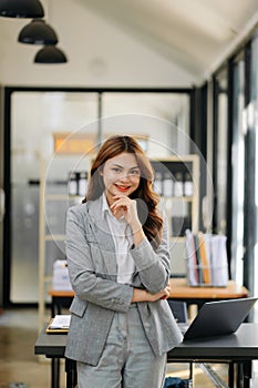 Confident business expert attractive smiling young woman holding digital tablet on desk in office