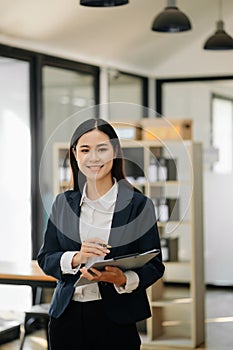 Confident business expert attractive smiling young woman holding digital tablet on desk in office