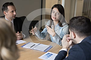 Confident business leader woman talking to colleagues on corporate meeting