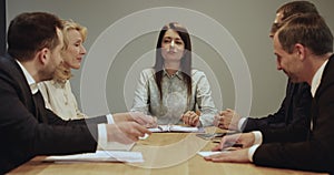 Confident business leader woman talking to different aged team