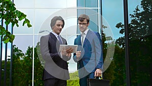 Confident business men in front of office building. Businessman and his colleague. Banking and financial market concept.