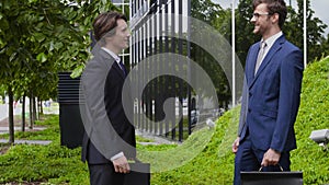 Confident business men in front of office building. Businessman and his colleague. Banking and financial market concept.