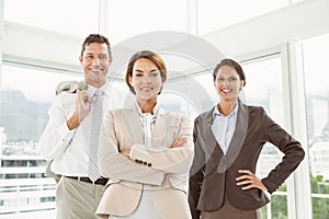 Confident business people with arms crossed in office