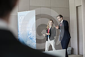 Confident business people discussing while walking in convention center