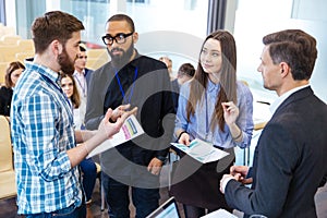 Confident business people standing and discussing financial report in office
