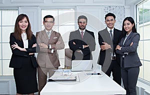 Confident business team standing and smiling in modern office lo