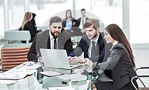 Confident business team working on laptop with financial records