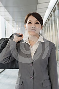 Confident business woman holding briefcase in modern city