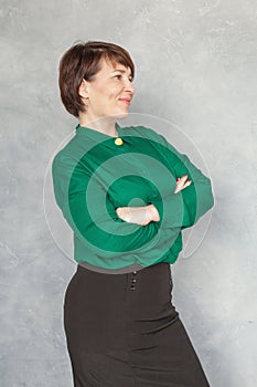 Confident business woman mature model looking aside on gray background