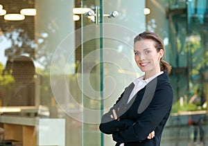 Confident business woman smiling by glass window