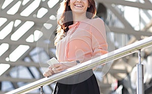 Confident business woman standing on the balcony of a modern office building