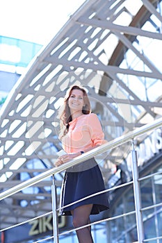 Confident business woman standing on the balcony of a modern office building