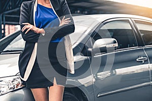 Confident business woman standing beside the car.