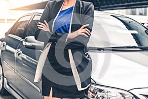 Confident business woman standing beside the car.