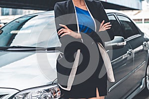 Confident business woman standing beside the car.