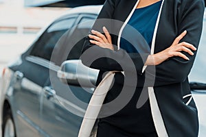 Confident business woman standing beside the car. uds