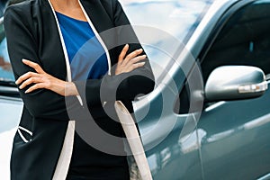 Confident business woman standing beside the car. uds