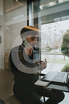 Confident businessman discussing profitable business strategies in a soundproof phone booth.
